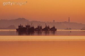 Travel. Editorial image. Fishing boats at sunset in Larache Harbour Marocco.